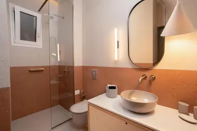 a bathroom with a sink and a toilet and a mirror at MelAngelo Villas A - Modern Studio near Port of Piraeus in Piraeus