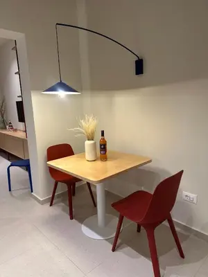 a table with a bottle of wine and two chairs at MelAngelo Villas A - Modern Studio near Port of Piraeus in Piraeus