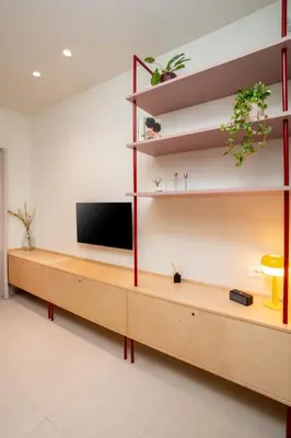 a living room with a tv on a wooden shelf at MelAngelo Villas A - Modern Studio near Port of Piraeus in Piraeus