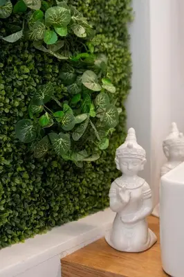 a white statue sitting on a table in front of a green wall at 180 jacuzzi with Acropolis sunset view in Athens