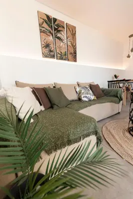 a living room with a couch and a plant at 180 jacuzzi with Acropolis sunset view in Athens