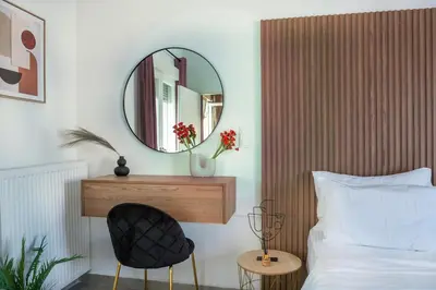 a bedroom with a mirror and a chair next to a bed at Hot tub with Acropolis view 1 minute from METRO TRAIN in Athens