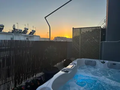 a bath tub on a balcony with a sunset in the background at Hot tub with Acropolis view 1 minute from METRO TRAIN in Athens