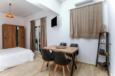a bedroom with a bed and a table and chairs at Evelyn's cozy house in Athens