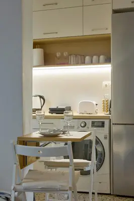 a kitchen with a table and two chairs with wine glasses at Modern & Cozy Studio in Kypseli in Athens