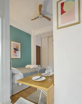 a living room with a table and a bed at Modern & Cozy Studio in Kypseli in Athens