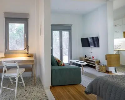 a living room with a couch and a desk and a television at Modern & Cozy Studio in Kypseli in Athens