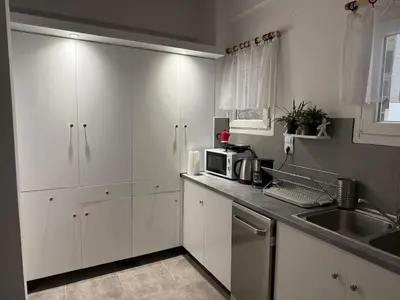a kitchen with white cabinets and a sink at Athenian sunlit central flat! in Athens