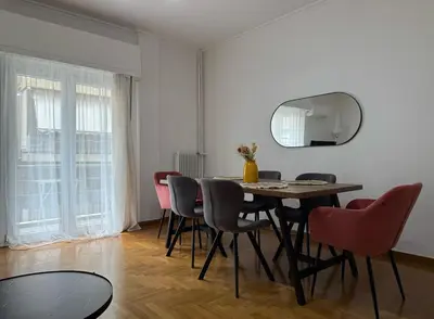 a dining room with a table and chairs and a mirror at Athenian sunlit central flat! in Athens