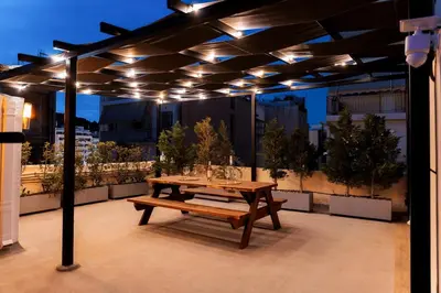 a wooden picnic table on a rooftop with lights at Romantic Garden Central Rooftop Gym Fast Wifi in Athens