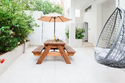 a patio with a table and a swing and an umbrella at Romantic Garden Central Rooftop Gym Fast Wifi in Athens