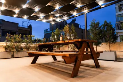 a wooden picnic table with wine glasses on it at Romantic Garden Central Rooftop Gym Fast Wifi in Athens