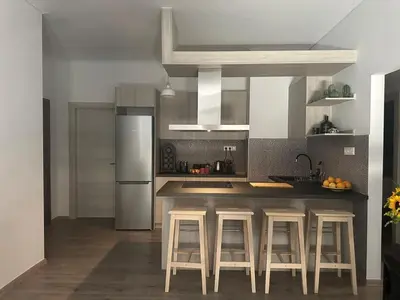 a kitchen with a counter with stools and a refrigerator at Spacious sunlit 3bd flat,2 bathroom best location! in Athens