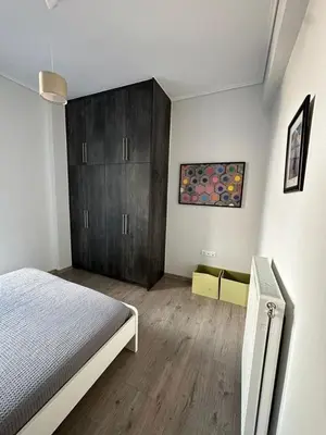a bedroom with a bed and wooden cabinets in it at Spacious sunlit 3bd flat,2 bathroom best location! in Athens