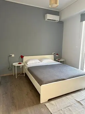a bedroom with a large bed and two tables at Spacious sunlit 3bd flat,2 bathroom best location! in Athens