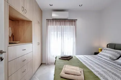 a small bedroom with a bed and a window at Suncity apartments with garden in Athens