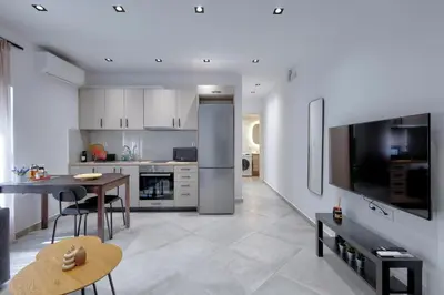 a kitchen and dining room with a table and a television at Suncity apartments with garden in Athens