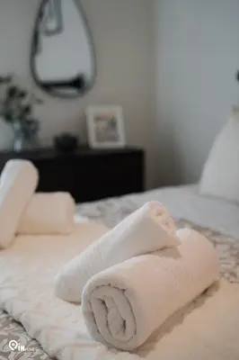 a towel laying on top of a bed at Irene's Home - Serene City Sanctuary in Athens in Athens