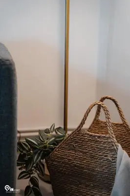 a brown basket sitting next to a couch with a plant at Irene's Home - Serene City Sanctuary in Athens in Athens