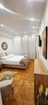 a bedroom with a bed and a wooden floor at Best Stay Athens Metro in Athens