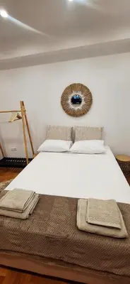 a bedroom with a large white bed with a mirror on the wall at Best Stay Athens Metro in Athens