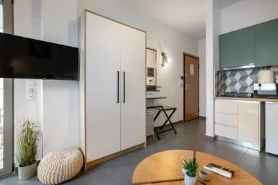 a living room with a large white cabinet and a table at Cassiopeia - Charming Studio & Balcony in Athens in Athens