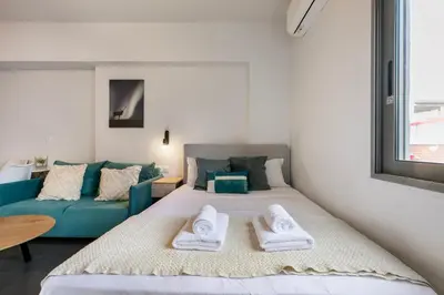 a bedroom with a bed and a blue couch at Cassiopeia - Charming Studio & Balcony in Athens in Athens