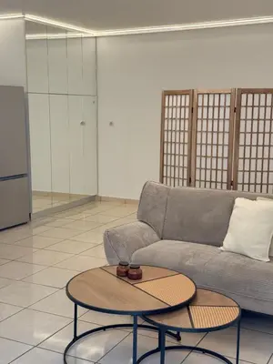 a living room with a couch and a table at Cozy studio 10minutes from airport in Markopoulo