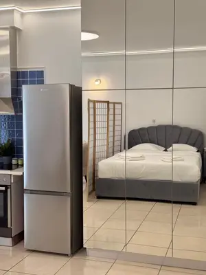 a bedroom with a bed and a refrigerator at Cozy studio 10minutes from airport in Markopoulo