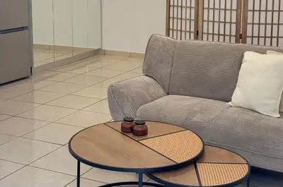 a living room with a couch and a table at Cozy studio 10minutes from airport in Markopoulo