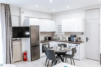 a kitchen with a table with chairs and a refrigerator at Sapfo in Athens