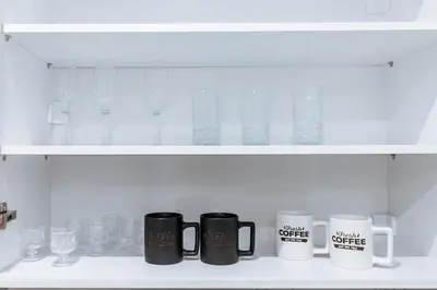 a row of coffee mugs sitting on a shelf at Sapfo in Athens