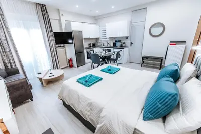 a bedroom with a large bed with blue pillows on it at Sapfo in Athens