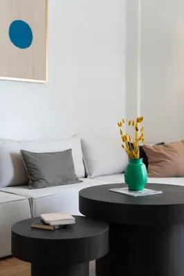 a living room with a couch and a table with a green vase at Stylish 4BR Top Floor w Private Rooftop Lounge in Athens