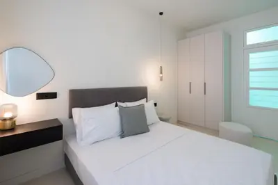 a white bedroom with a white bed and a window at Stylish 4BR Top Floor w Private Rooftop Lounge in Athens