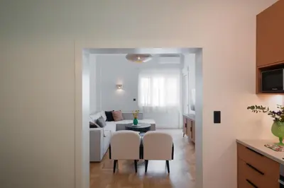 a kitchen and living room with a table and chairs at Stylish 4BR Top Floor w Private Rooftop Lounge in Athens