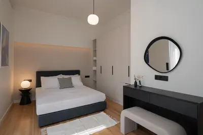 a bedroom with a bed and a mirror at Stylish 4BR Top Floor w Private Rooftop Lounge in Athens