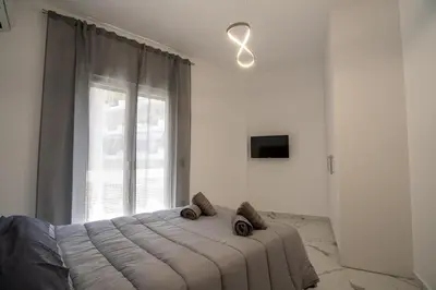 a bedroom with a large bed in front of a window at Athenian Hospitality in Athens