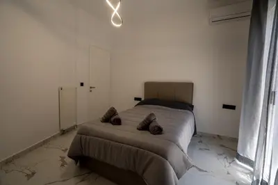 a bedroom with a bed in a white room at Athenian Hospitality in Athens