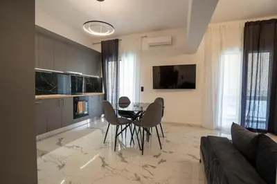 a kitchen with a table and chairs in a room at Athenian Hospitality in Athens