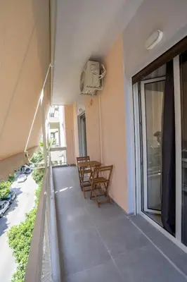 a balcony with chairs and a table on a building at Athenian Hospitality in Athens
