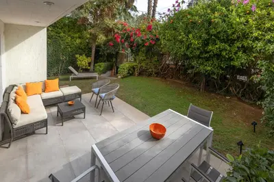 a patio with a couch and a table and chairs at Private Garden Duplex in Voula by GHH in Athens