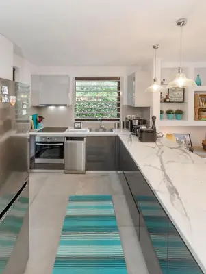 a kitchen with stainless steel appliances and a large counter top at Private Garden Duplex in Voula by GHH in Athens