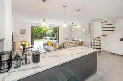 a kitchen with a counter top and a living room at Private Garden Duplex in Voula by GHH in Athens