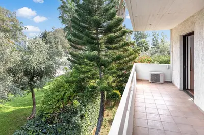 a large pine tree on the balcony of a house at Private Garden Duplex in Voula by GHH in Athens