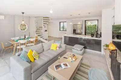 a living room with a couch and a table at Private Garden Duplex in Voula by GHH in Athens
