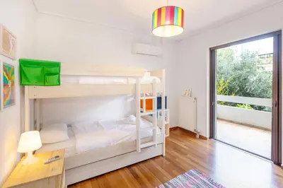 a bedroom with bunk beds and a large window at Private Garden Duplex in Voula by GHH in Athens