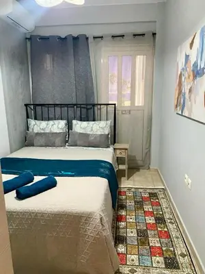 a bedroom with a large bed with blue sheets at Athens Victoria's Family Apartment in Athens