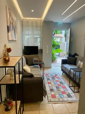 a living room with a couch and a tv at Athens Victoria's Family Apartment in Athens
