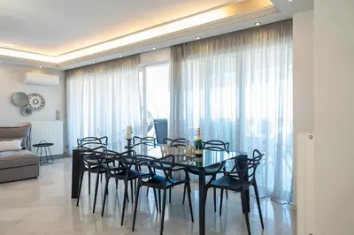 a dining room with a black table and chairs at Luxury Apartment in Glyfada with Sea View in Athens